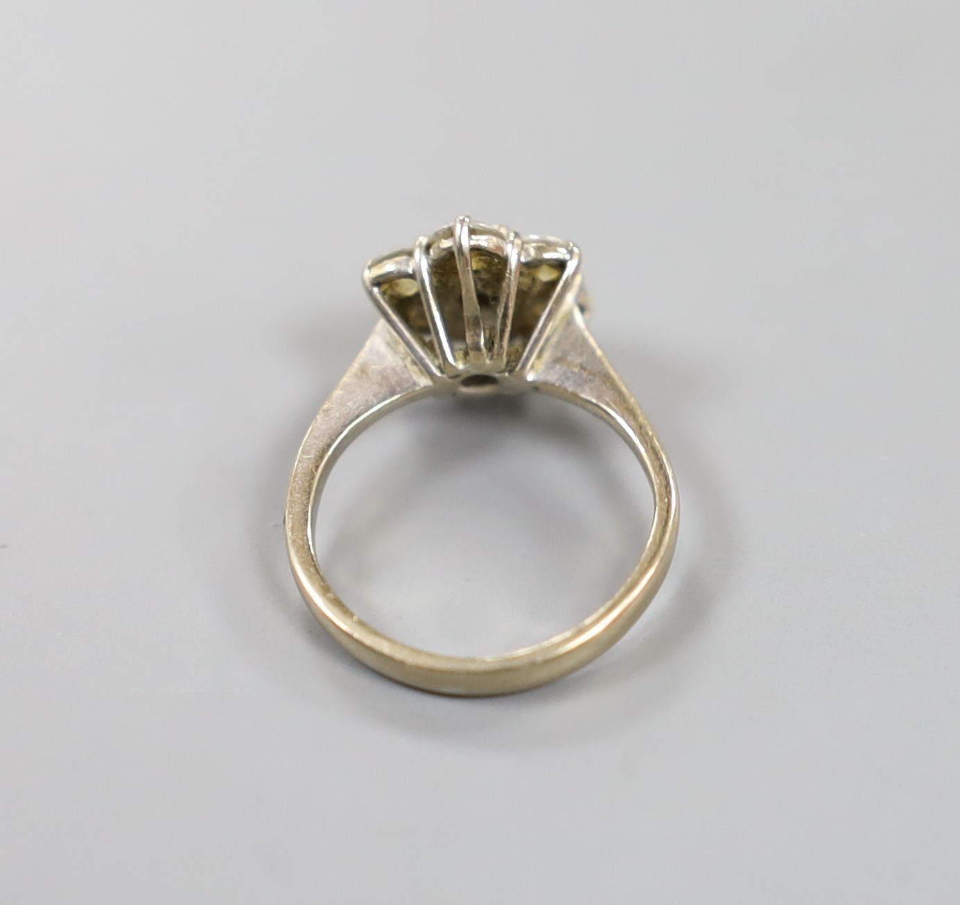 An 18ct and seven stone diamond set flower head cluster ring, size F/G, gross weight 3.2 grams.